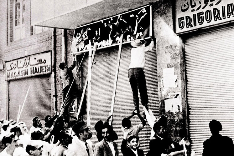 مردم تهران در حال درآوردن تابلوی نئون از دفتر اطلاعات و انتشارات شرکت نفت انگلیس و ایران - خیابان نادری - تهران - خرداد ۱۳۳۰